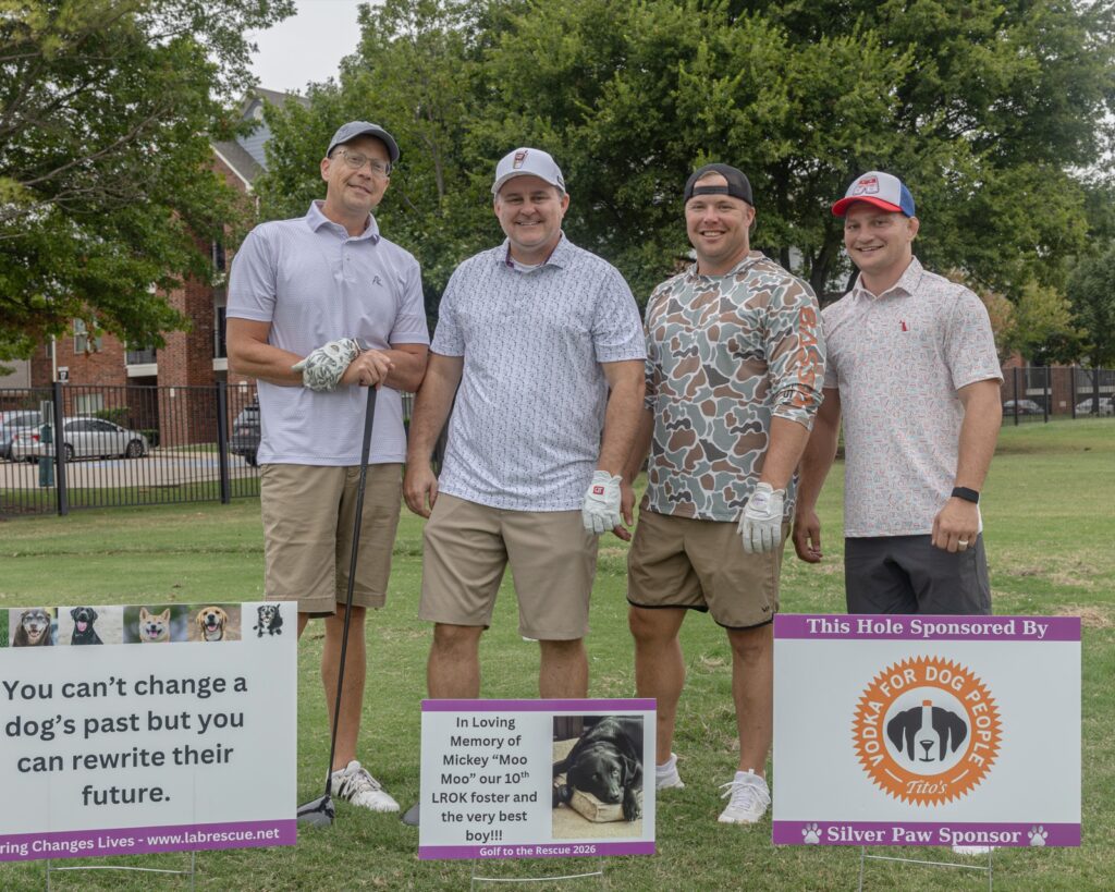 Four golfers standing beside hole sponsor signs at Golf to the Rescue 2026